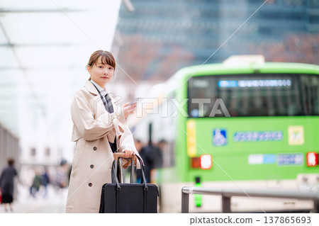 一位年輕的女商人正在城市裡等計程車。 一位年輕的女商人正在城市裡等計程車。 137865693
