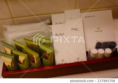 A set of high-quality amenities neatly arranged on the bathroom counter of a luxury hotel. A set of high-quality amenities neatly arranged on the bathroom counter of a luxury hotel. 137865706