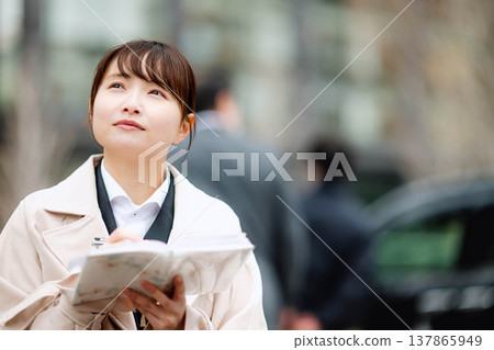 一位年輕的女商人正在查看她的日程表。 137865949