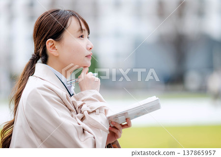 一位年輕的女商人正在查看她的日程表。 137865957
