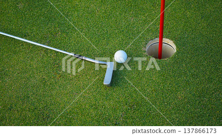 Golf clubs and golf balls on a green lawn in a beautiful golf course with morning sunshine. 137866173