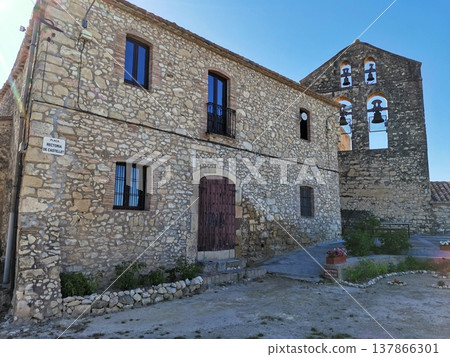 Rustic stone house and old church bell tower in Castellet village, Spain. Rustic stone house and old church bell tower in Castellet village, Spain. 137866301