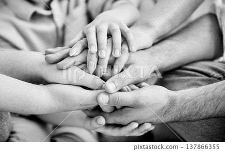 Close-up of several hands placed on top of one another in stack. All family members showing their support to each other. Concept of togetherness, unity, teamwork, family. Black and white image. Close-up of several hands placed on top of one another in stack. All family members showing their support to each other. Concept of togetherness, unity, teamwork, family. Black and white image. 137866355