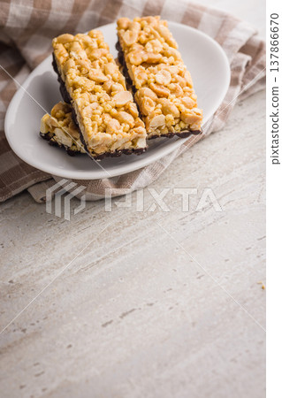 Stacked Peanut Granola Bars With Chocolate Coating On Plate, Crunchy Snack Food Stacked Peanut Granola Bars With Chocolate Coating On Plate, Crunchy Snack Food 137866670