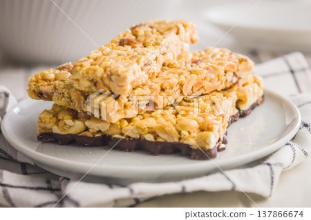 Stacked Peanut Granola Bars With Chocolate Coating On Plate, Crunchy Snack Food Stacked Peanut Granola Bars With Chocolate Coating On Plate, Crunchy Snack Food 137866674