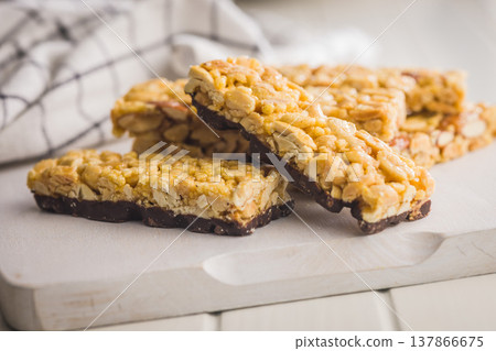 Crunchy Peanut Granola Bars With Chocolate Base Stacked On Wooden Board For Snack Or Breakfast Crunchy Peanut Granola Bars With Chocolate Base Stacked On Wooden Board For Snack Or Breakfast 137866675