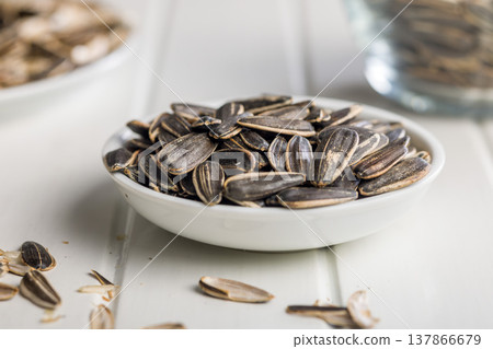 Bowl of Sunflower Seeds and Empty Shells on Plate Rustic Snack Close-Up 137866679