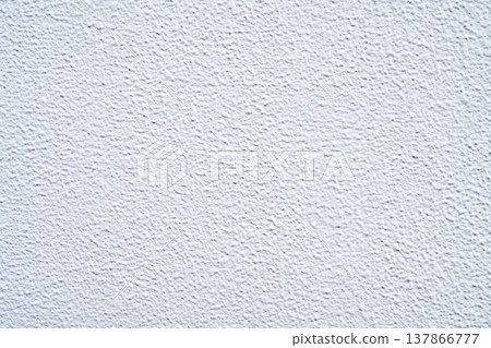 Close-up view of a white textured wall with a rough stippled finish. Clean minimal background for architecture, interior design, and construction themes. Grainy plaster surface with soft lighting. Close-up view of a white textured wall with a rough stippled finish. Clean minimal background for architecture, interior design, and construction themes. Grainy plaster surface with soft lighting. 137866777