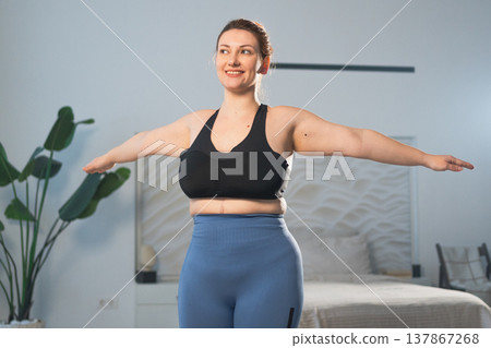 Fitness workout training. Woman practicing fitness at home. Plus size female doing sports exercise at home indoor. Girl in sportswear have workout weight training for weight loss. Sport and fitness Fitness workout training. Woman practicing fitness at home. Plus size female doing sports exercise at home indoor. Girl in sportswear have workout weight training for weight loss. Sport and fitness 137867268