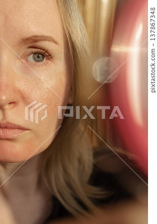 Close-up of female face with enlarged pores and oily skin, visible texture, redness on chin. Natural light beauty portrait, skincare concerns, dermatology concept. Close-up of female face with enlarged pores and oily skin, visible texture, redness on chin. Natural light beauty portrait, skincare concerns, dermatology concept. 137867348