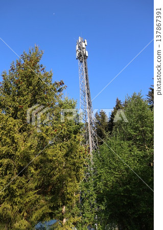A tall tower with a cell phone antenna on top 137867391