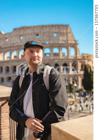 Handsome 30s tourist visiting Colosseum in Rome, Italy. Young man taking photo in front of famous Italian landmark Handsome 30s tourist visiting Colosseum in Rome, Italy. Young man taking photo in front of famous Italian landmark 137867705