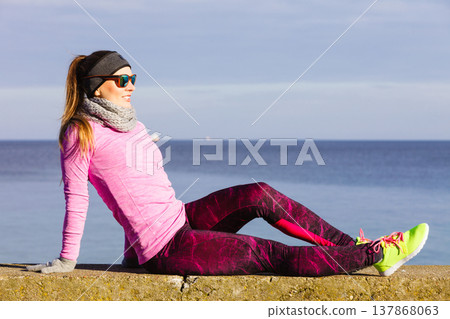 Woman resting after doing sports outdoors on cold day Woman resting after doing sports outdoors on cold day 137868063