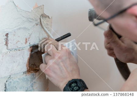 Electrician Installing Wall Socket While Drilling Concrete Hole With Exposed Wires And White Electrical Box In Modern Home Renovation Scene Electrician Installing Wall Socket While Drilling Concrete Hole With Exposed Wires And White Electrical Box In Modern Home Renovation Scene 137868148