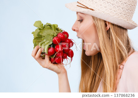 Happy woman biting radish Happy woman biting radish 137868236