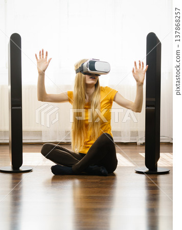 Girl wearing virtual reality goggles at home Girl wearing virtual reality goggles at home 137868257