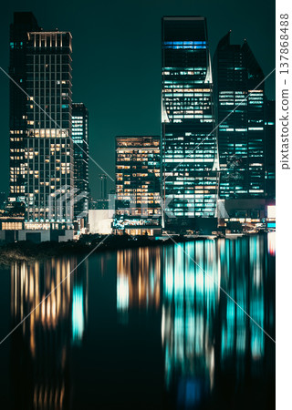 illuminated big city skyline at night with mirrored water reflection, modern high-rise skyscrapers at urban dusk, downtown mirroring on swimming pool, Bangkok Thailand 137868488