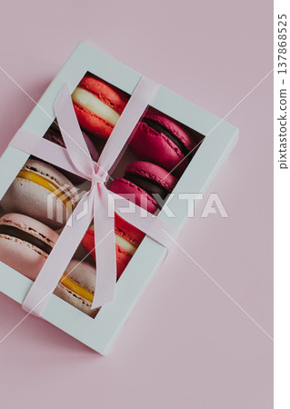 Tasty french macarons in a box on a pink pastel background. 137868525