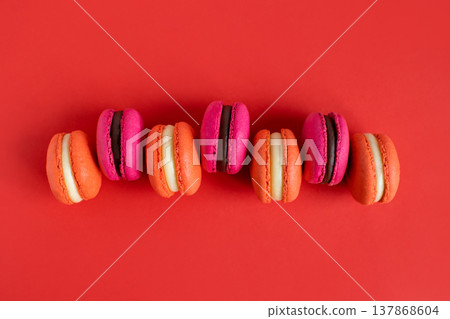 Tasty french macarons on a red background. Tasty french macarons on a red background. 137868604