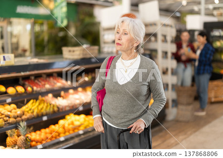 Elderly woman chooses products in grocery store 137868806