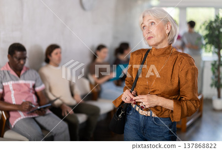 Mature woman standing in reception area 137868822