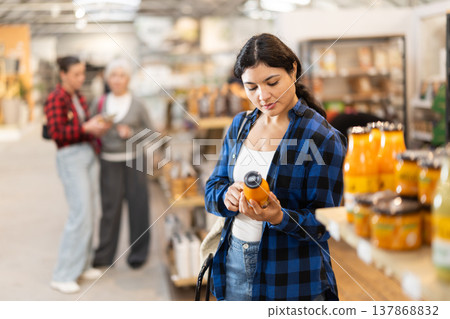 Young woman chooses juice in grocery store Young woman chooses juice in grocery store 137868832