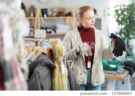While shopping, teen girl browsing goods items and choose elect warm gloves in store While shopping, teen girl browsing goods items and choose elect warm gloves in store 137868865