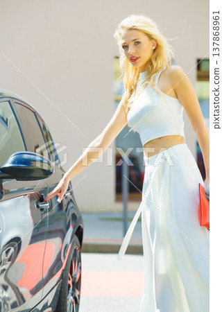Fashionable woman opening car Fashionable woman opening car 137868961