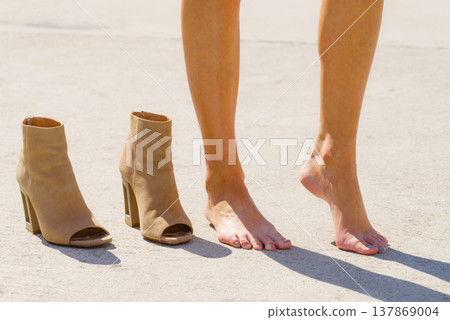 Barefoot woman next to shoes 137869004