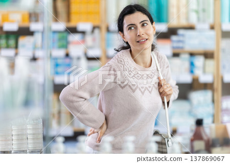 Woman holding her lower back in pharmacy 137869067