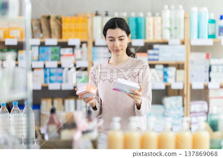 Girl in autumn clothes looking for medicine in pharmacy 137869068