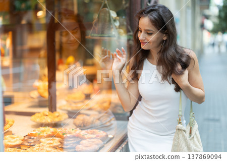 Young woman chooses baked goods in bakery 137869094