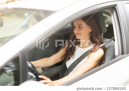 Young woman drives car in city 137869105