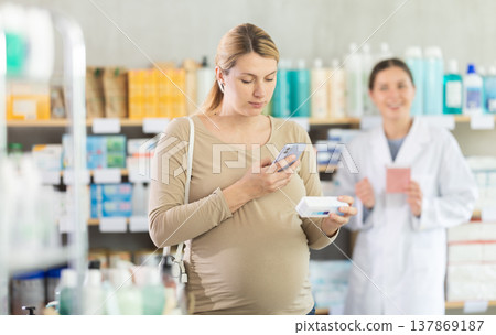 Pregnant woman using phone to verify supplement safety Pregnant woman using phone to verify supplement safety 137869187