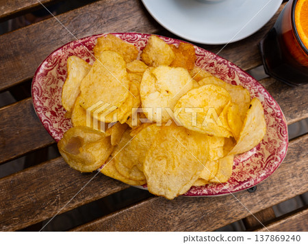 Plate of crispy potato chips served with glass of red vermouth Plate of crispy potato chips served with glass of red vermouth 137869240