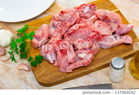 Raw rabbit meat with garlic and greens during cooking Raw rabbit meat with garlic and greens during cooking 137869262