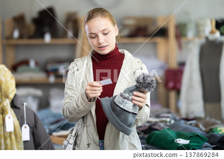 Teenage girl choosing hat in clothing store Teenage girl choosing hat in clothing store 137869284