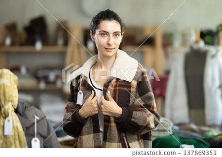 Armenian woman trying on a plaid jacket in a store Armenian woman trying on a plaid jacket in a store 137869351