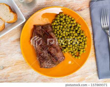 Grilled beef steak with pickled green peas on plate 137869371