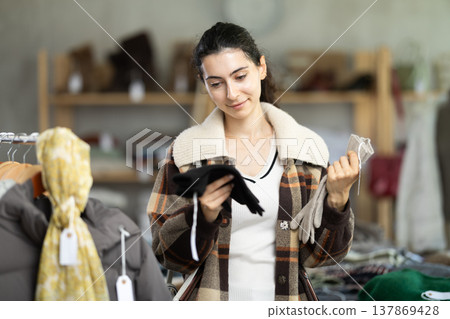 Armenian woman near showcase examine goods, buying gloves. 137869428