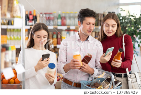 Couple of man and woman with girl scanning qr code of sauces 137869429