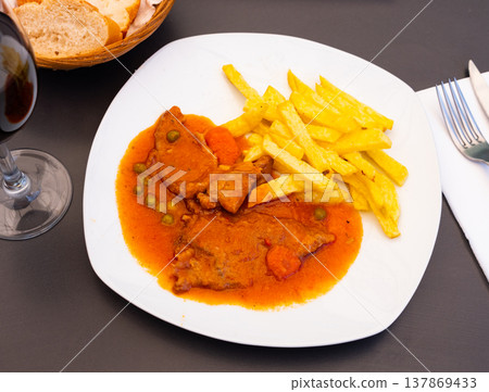Juicy pork stew in sauce with fried potato slices 137869433