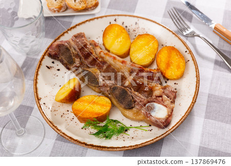 Grilled beef spare ribs with baked potatoes and greens Grilled beef spare ribs with baked potatoes and greens 137869476