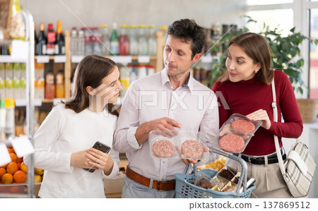 Couple of man and woman with girl choosing hamburger or entrecote Couple of man and woman with girl choosing hamburger or entrecote 137869512