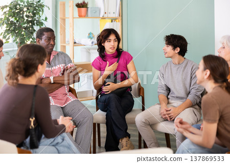 Diverse group of people sitting in a circle and chatting Diverse group of people sitting in a circle and chatting 137869533