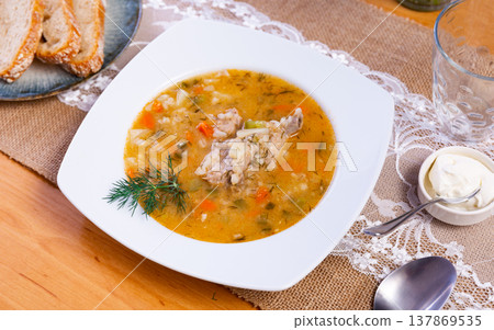 National Russian dish is Pickle soup with meat, cooked on basis of pickled cucumbers and pearl barley 137869535