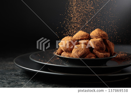 Chocolate truffles are sprinkled with cocoa powder. 137869538