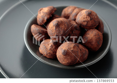 Black plate with chocolate truffles. Black plate with chocolate truffles. 137869553