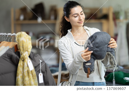 Armenian woman near showcase examine goods, fur hat. 137869607