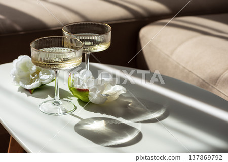 Champagne Glasses with Flowers under Sunlight. Elegant Celebration Scene Champagne Glasses with Flowers under Sunlight. Elegant Celebration Scene 137869792
